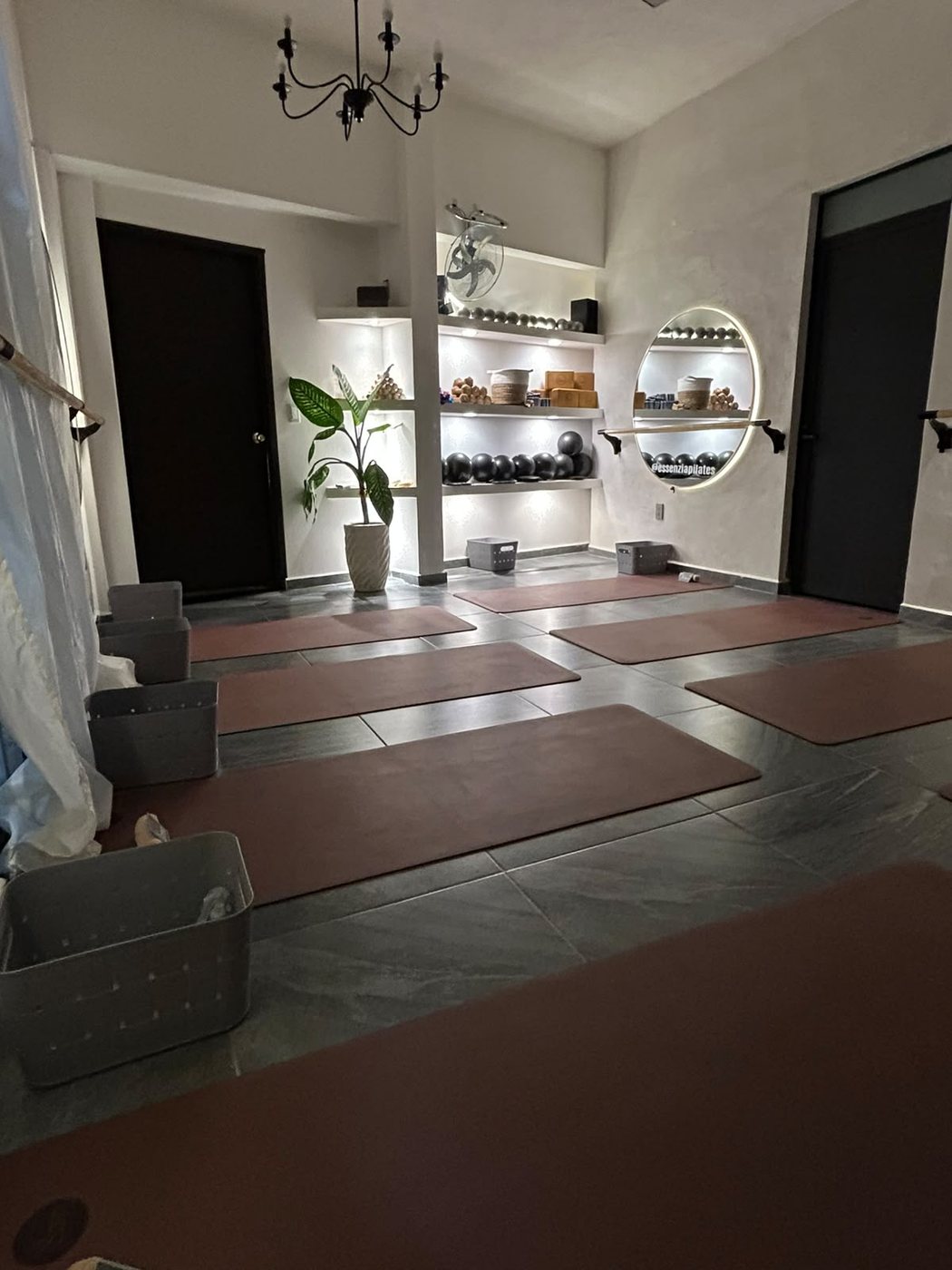 Tapetes de yoga en tonos terracota dispuestos en el piso del estudio.